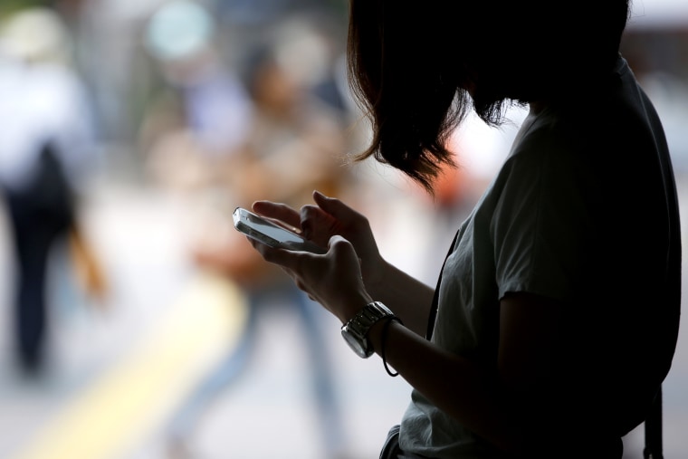 Image: A woman uses her phone in Tokyo on June 30, 2014.