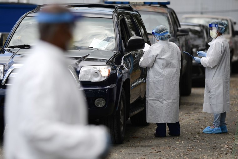 Image: Health Department nurses collect samples from doctors, paramedics and police officers at a drive-thru checkpoint to perform molecular tests that detect the new coronavirus virus, in San Juan, Puerto Rico