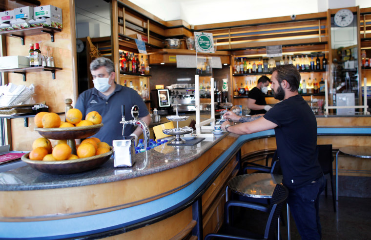 Image: A man in Milan, Italy drinks a coffee in a bar, as shops and restaurants are allowed to reopen on Monday.