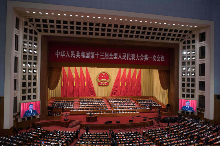 Image: Chinese President Xi Jinping (at podium) delivering a speech during the closing session of the National People's Congress at the Great Hall of the People in Beijing
