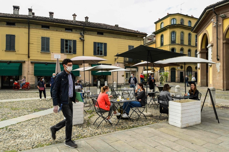 Image: Residents have a drink at a cafe terrace on Wednesday in Codogno, one of the villages at the epicenter of the country's outbreak.