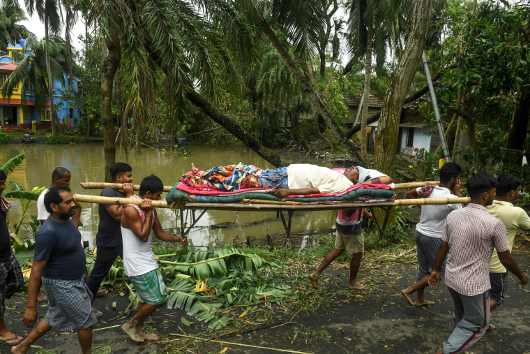 Image: Residents carry Tapas Pramanik (C), 41, after his leg got broken by a tree fall the night before, in search of an ambulance or vehicle to take him to the hospital, following the landfall of cyclone Amphan in Khejuri area of Midnapore, West Bengal,