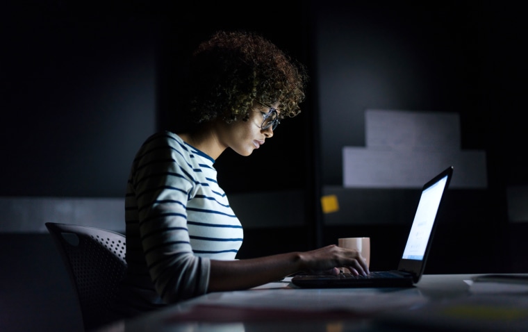 Concentrated woman working late hours with her laptop