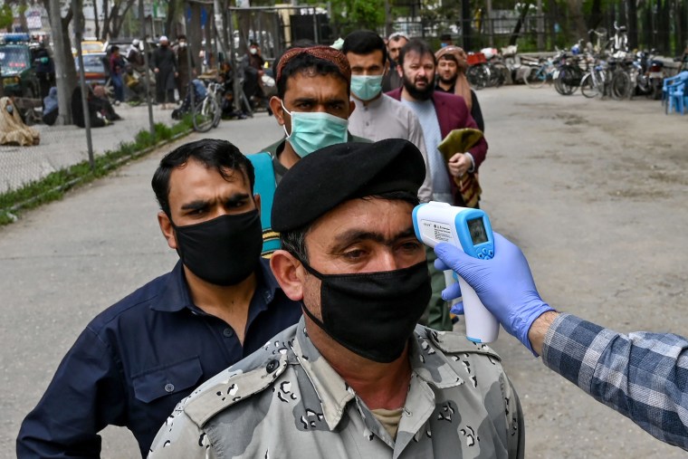Image: A health worker checks the body temperature of a devotee as a preventive measure against the COVID-19 coronavirus before the Friday prayers on the first day of the Muslim holy month of Ramadan at Wazir Akbar Khan mosque