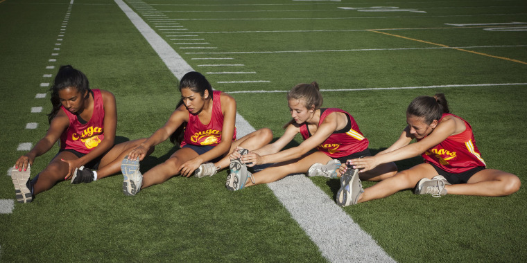 Teenage runners stretching before exercise