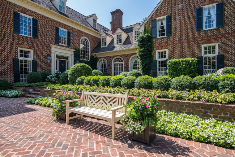 The exterior of the home features dozens of windows and well-manicured grounds. 