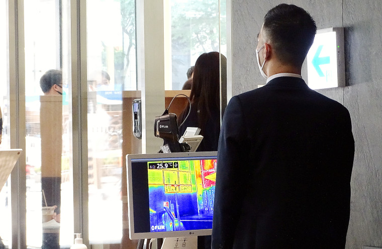 Image: A security worker monitors the temperature levels of building.