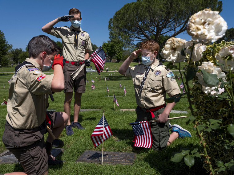 Image: Nathan Federoff and his brothers, Xander and Christian, scouts with the Tierra Rejada District, salute a grave at the Pierce Brothers Memorial Park in Los Angeles on May 23.