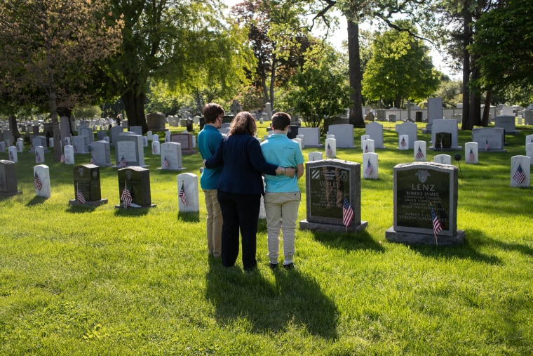 Image: Traci Voelke and her sons, AJ and Benjamin, visit the grave of her husband, U.S. Army Maj. Paul Voelke, at West Point, N.Y., on May 24. Military cemeteries are closed to the public and only open to veterans' families due to coronavirus restrictions