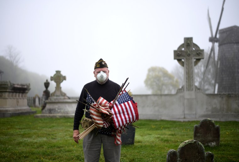 Image: Retired Marine Corps Brian Carbine, 78, places American flags at veteran gravesites at the South End Cemetery in East Hampton, N.Y., on May 23. Carbine served in the Vietnam War and Desert Storm.