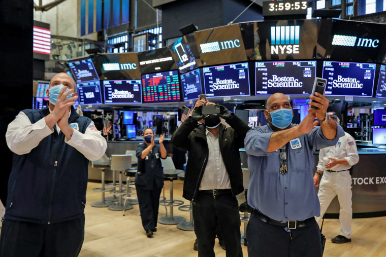 Image: Workers celebrate the during closing bell, as they prepare for the return to trading, on the floor at the NYSE in New York