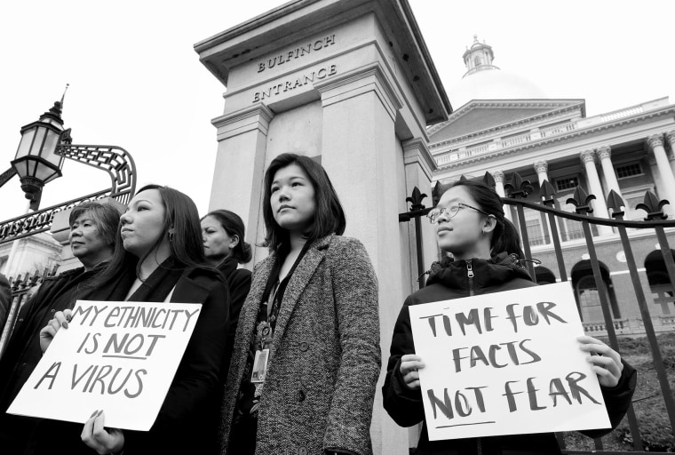 Members of Massachusetts' Asian American Commission stand together during a protest on the steps of the State House in Boston on March 12.