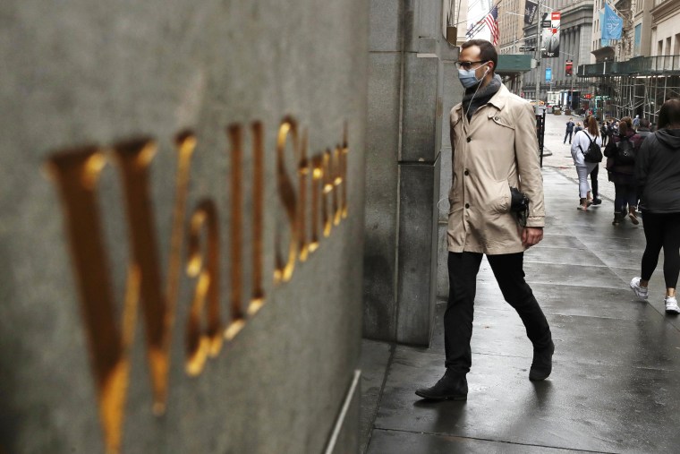 Image: A man wears a protective mask as he walks on Wall Street during the coronavirus outbreak in New York