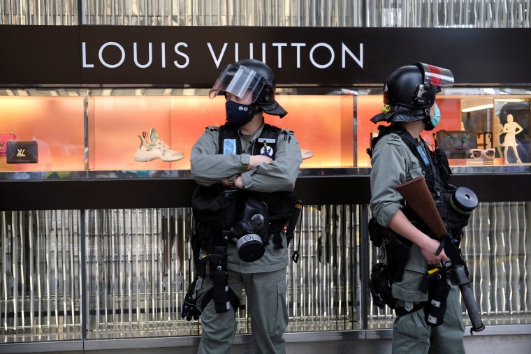 Image: Riot police stand guard outside a Louis Vuitton shop during a protest against Beijing's plans to impose national security legislation in Hong Kong