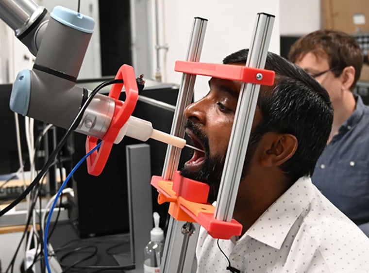 Image: Thiusius Rajeeth Savarimuthu demonstrates his team's automatic throat swab robot.