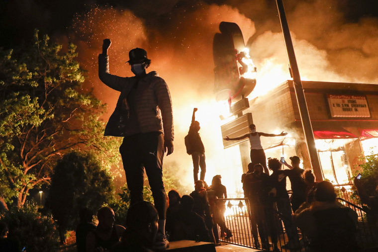 Image: Protestors demonstrate outside of a burning fast food restaurant, Friday, May 29, 2020, in Minneapolis.