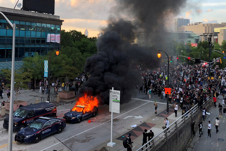 Image: An Atlanta Police car burns as people protest near CNN Center in Atlanta