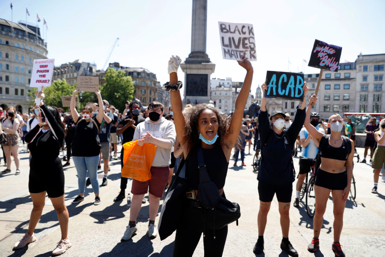 Image: People hold up signs during a protest in Trafalgar Square in London on May 31, 2020.