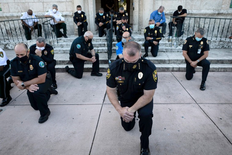Image: Police kneel during a rally in Coral Gables, Florida, on Saturday in response to the death of George Floyd.