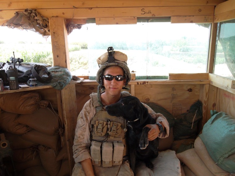 A soldier hugs a military dog named Blue.