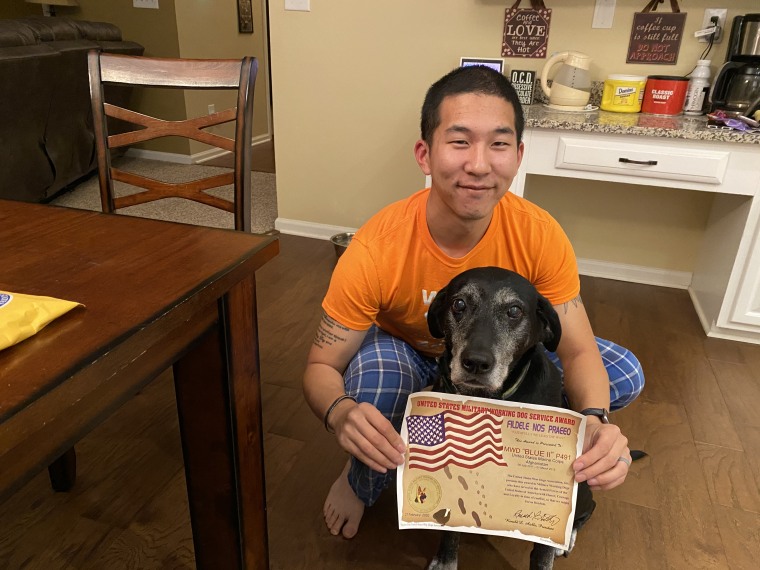 Byung Kang and Blue display a certificate recognizing her military service.