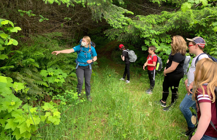 Campers and a counselor in a face mask go on a socially-distanced nature hike at Camp Wilani in Veneta, Oregon. The camp just hosted its first campers of the COVID-19 era last week.