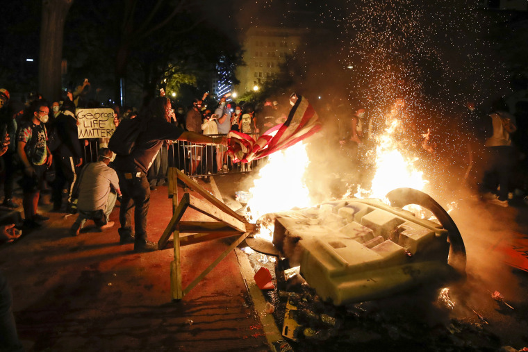 Image: Demonstrators start a fire