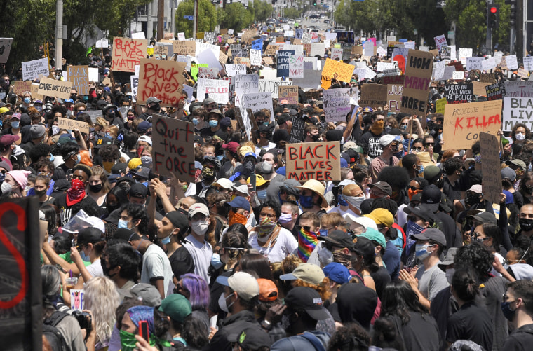 Demonstrators sit in an intersection during a protest in Los Angeles on Saturday, May 30, 2020, over the death of George Floyd.