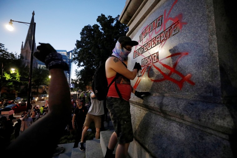 Image: A protester defaces a Confederate monument during nationwide unrest following the death in Minneapolis police custody of George Floyd, in Raleigh