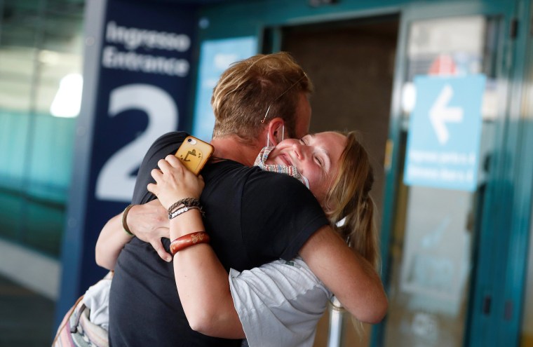 Image: Andrea Monti from Italy and Katharina Scherf from Germany hug upon her arrival at Fiumicino Airport, as Italy eases movement between regions, while the country unwinds its rigid lockdown due to the coronavirus disease (COVID-19) outbreak, in Rome,