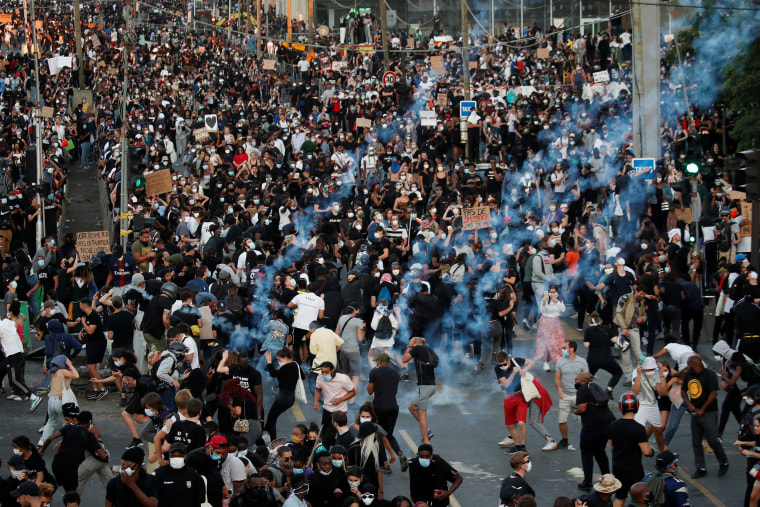 Image: People in Paris, France run from tear gas as they attend a banned demonstration on Tuesday.