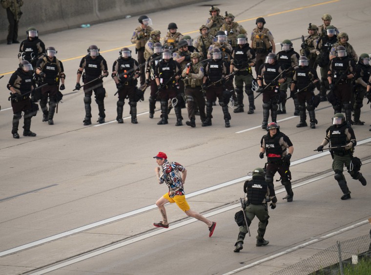 A protester tries to elude police officers as they try to disperse people during a protest in Minneapolis on May 31, 2020.