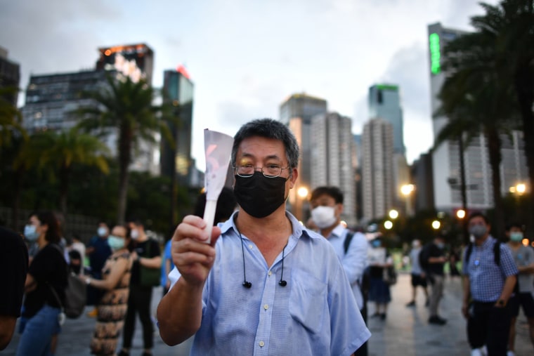 Image: A man holds up a candle in remembrance outside Victoria Park in Hong Kong
