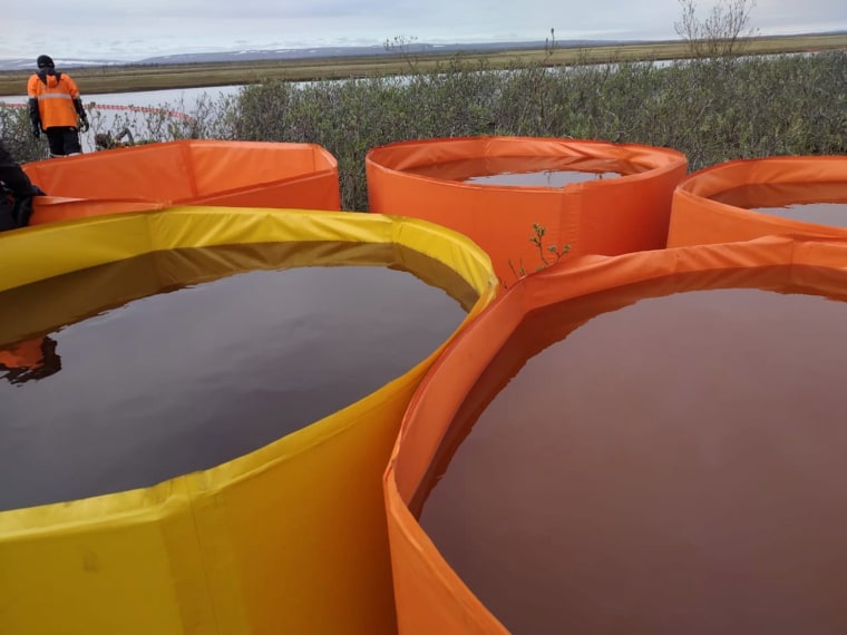 Image: Rescuers work at the site of a huge leak of fuel into the river after an accident at a power plant outside Norilsk