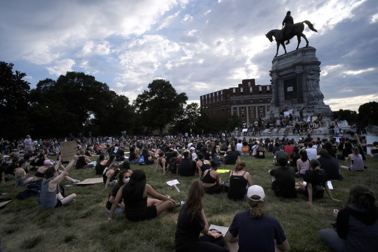 Image: Protesters sit near the statue of Robert E. Lee on Monument Avenue in Richmond, Va.