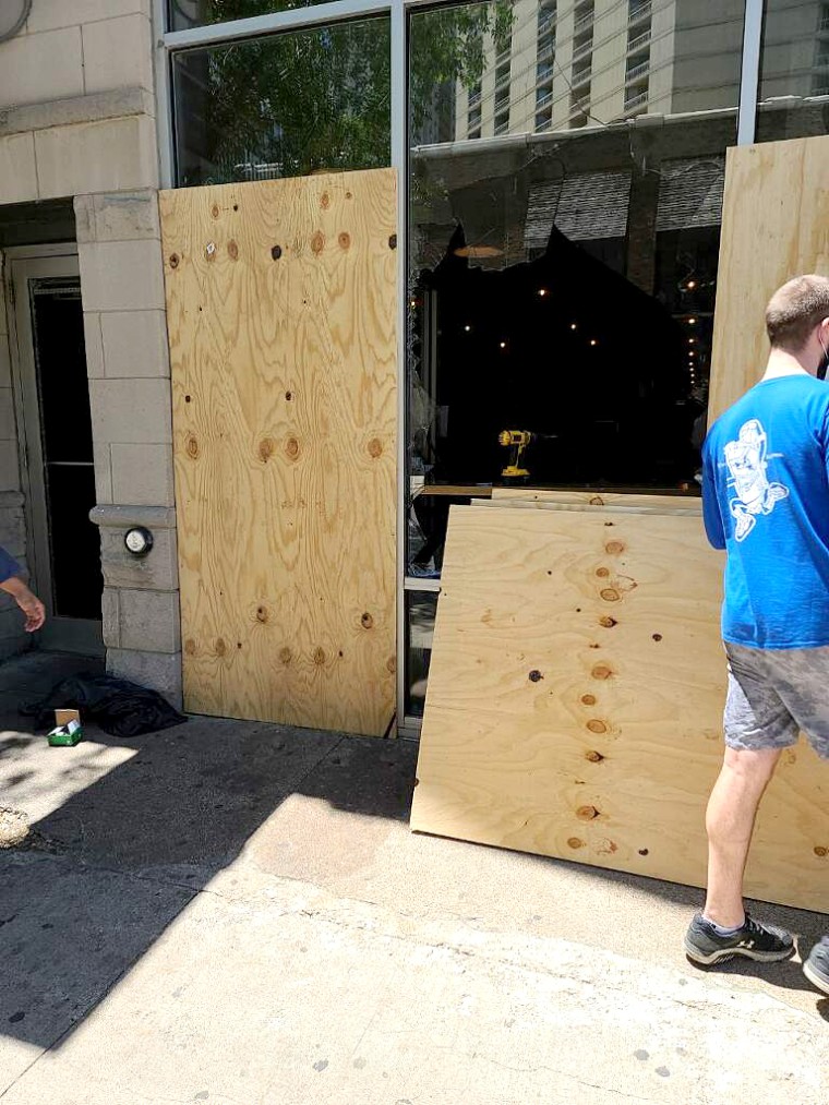 Boards are put up after the Downtown Chicago branch of Seoul Taco was vandalized on May 30, 2020.