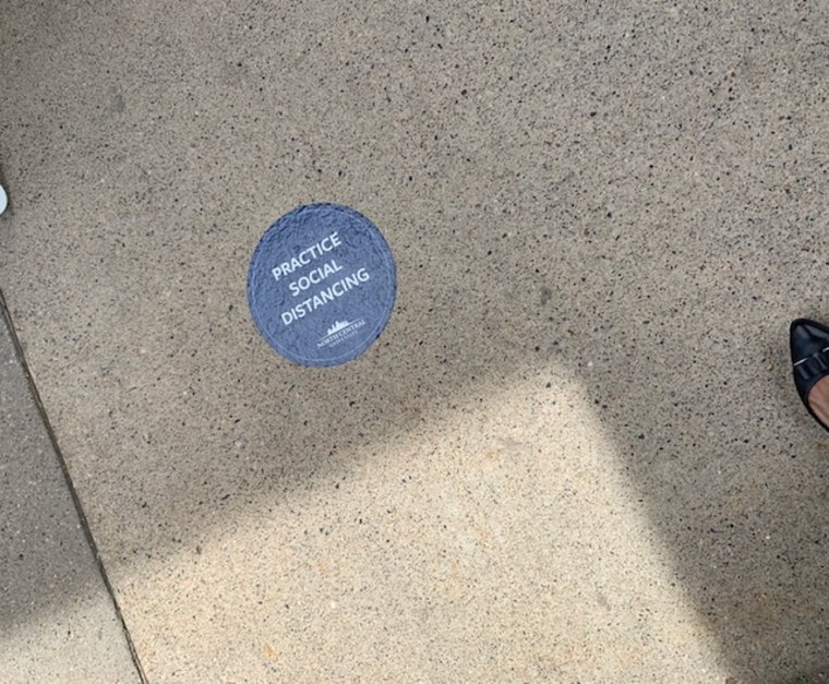 Navy blue stickers were placed along the sidewalks outside George Floyd's service that read "PRACTICE SOCIAL DISTANCING."