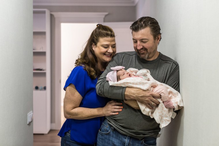 Image: Darlene Straub, 45, and Chris Straub, 43, a couple from Texas, hold their newborn baby, Sophia, born via surrogacy, in a rented apartment in 
