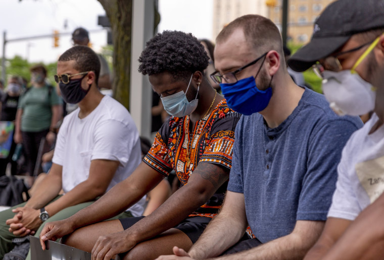 Demonstrators lower their heads for a moment of silence for victims of police brutality on June 4, 2020 in Detroit.