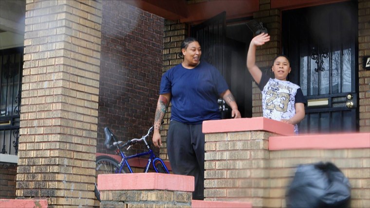 Lasheena Price and her son, Larrone, 9, a second grader at Detroit's New Paradigm Loving Academy, wave goodbye to Dungey. 
