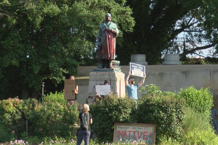 Protesters gather in front of a statue of Christopher Columbus in Richmond, Va.
