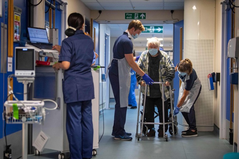 Image: Rehab Support Workers perform a physiotherapy treatment on patient Michael Kidd, 82, as the first patients are admitted to the NHS Seacole Centre at Headley Court, Surrey