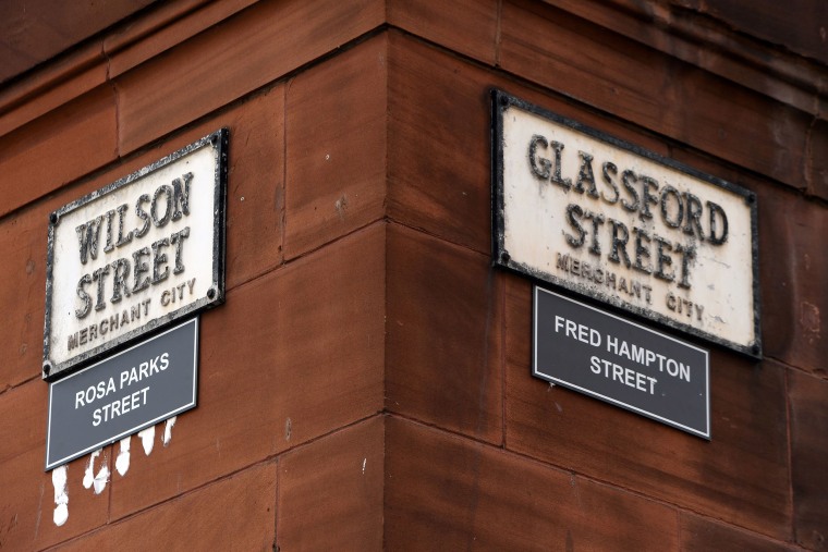 Image: Signs renaming Wilson Street as Rosa Parks Street, the American activist in the civil rights movement,and Glassford Street as Fred Hampton Street, the American activist and revolutionary socialist, are displayed in the Merchant City area of Glasgow