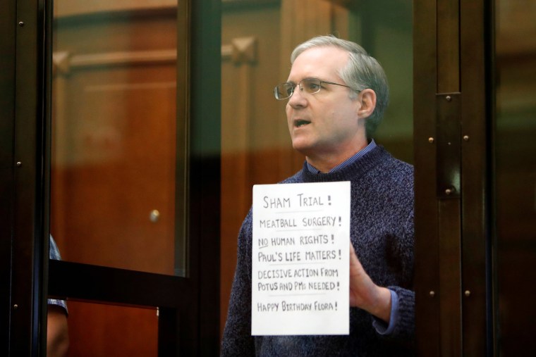 Image: Former U.S. Marine Paul Whelan, who was detained and accused of espionage, holds a sign as he stands inside a defendants' cage during his verdict hearing in Moscow, Russia