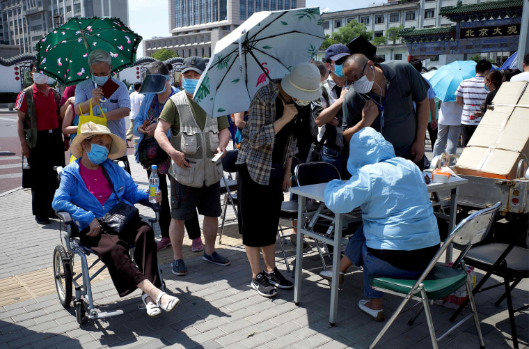 Image: Residents living by or who have visited the Xinfadi Market, a wholesale food market where a new COVID-19 coronavirus cluster has emerged, wait in line to be tested for the disease in Beijing