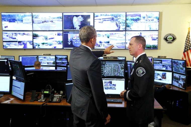 Obama speaks with Thomson as he tours the Camden County Police Department's Real-Time Tactical Operational Intelligence Center in Camden, New Jersey
