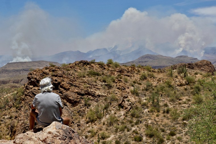 Image: A man watches a portion of the Bush fire burn through the Tonto National Forest from Apache Junction, Ariz.