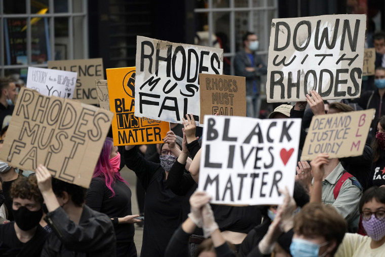 Image: Demonstrators hold placards during a protest called by the Rhodes Must Fall campaign on June 9, 2020 in Oxford, England.