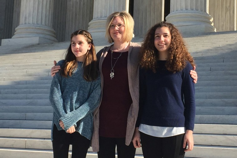 Image: Kendra Espinoza of Kalispell, Montana, center, stands with her daughters Naomi and Sarah outside the U.S. Supreme Court