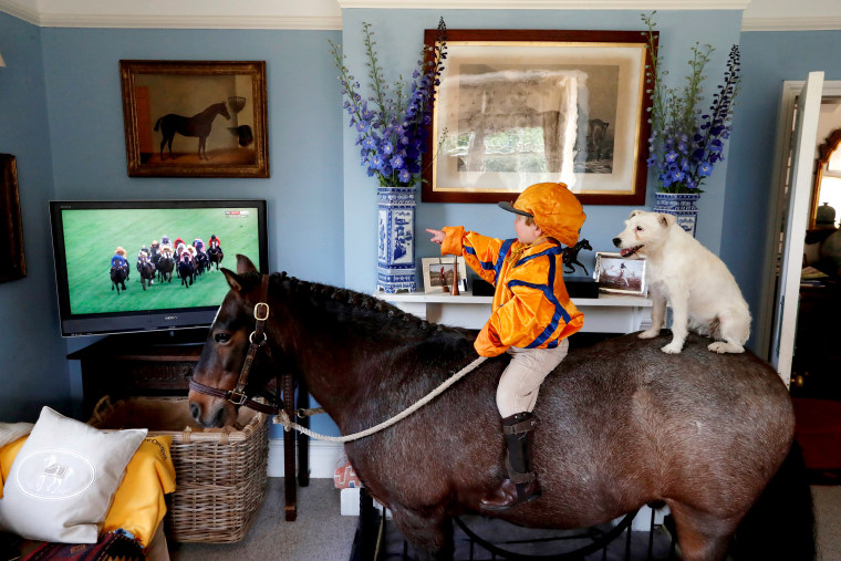 Image: Merlin Coles 3, watches the horse racing from Royal Ascot on TV at his home